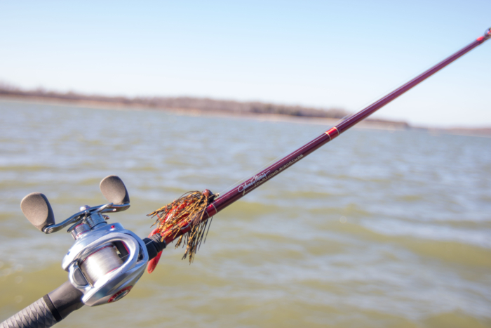 The Bass Pro Shops Johnny Morris Platinum Signature Rod in front of a lake.