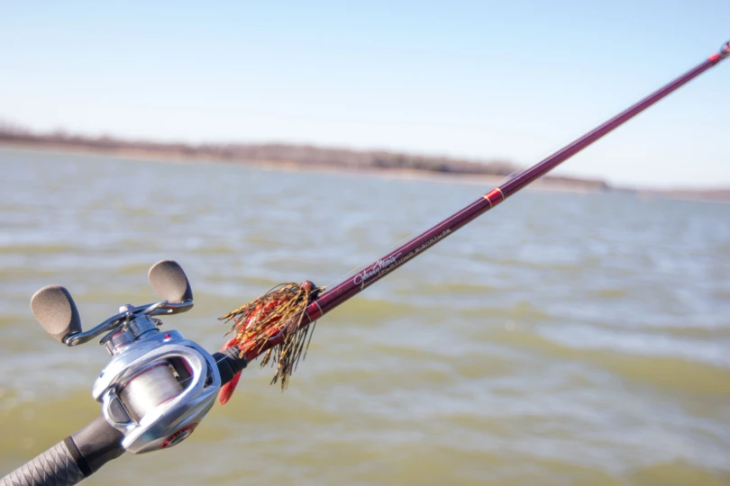 The Bass Pro Shops Johnny Morris Platinum Signature Rod in front of a lake.