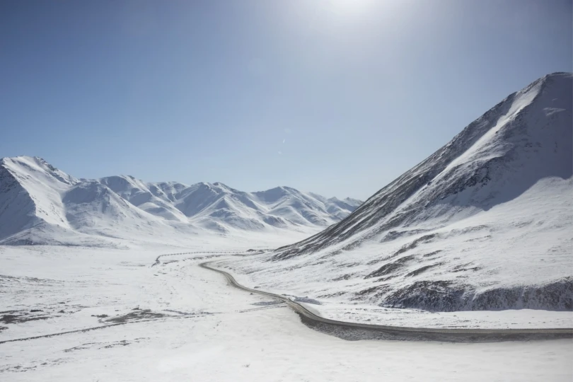 snowy mountainous landscape with narrow road