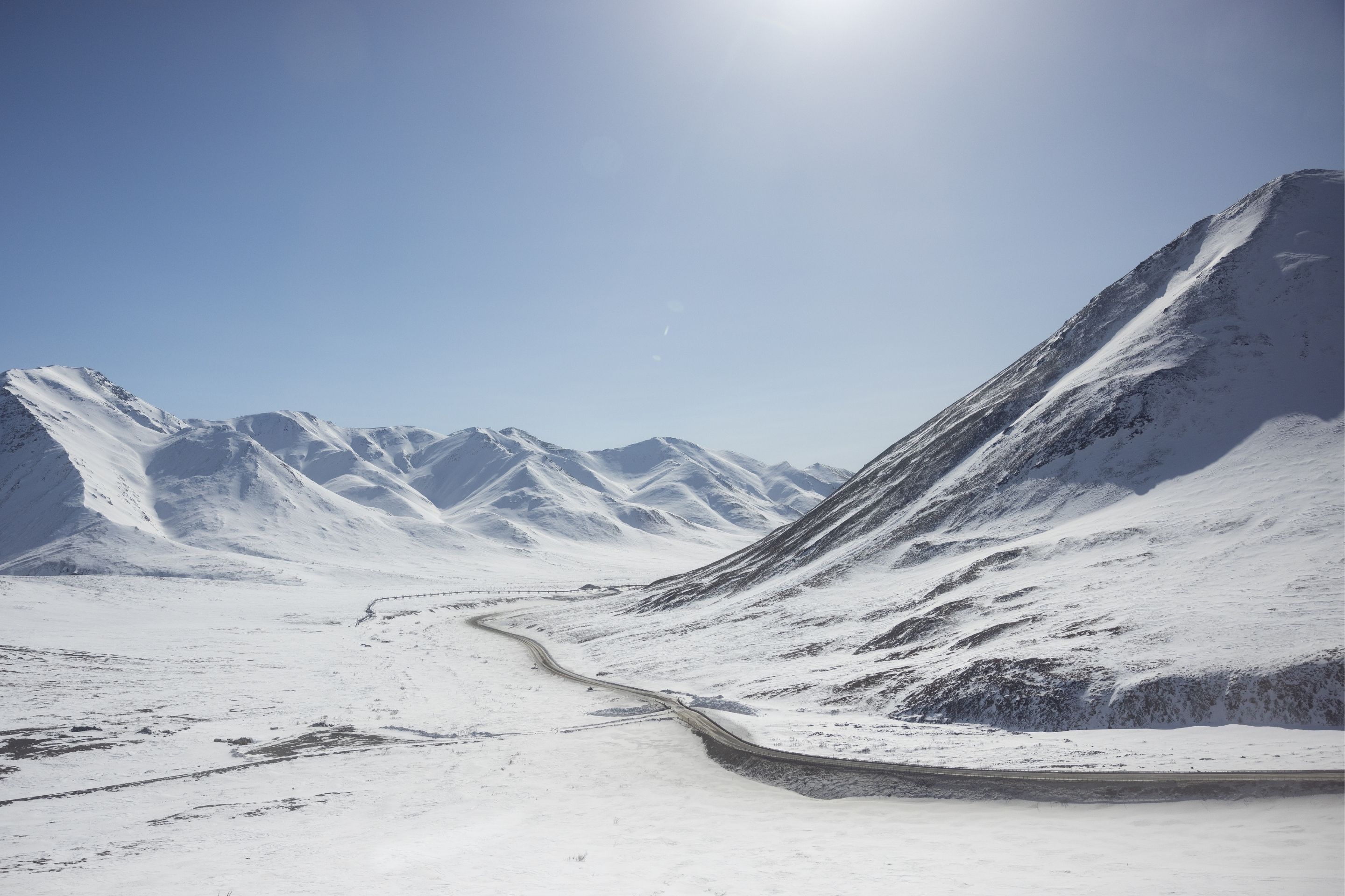 snowy mountainous landscape with narrow road