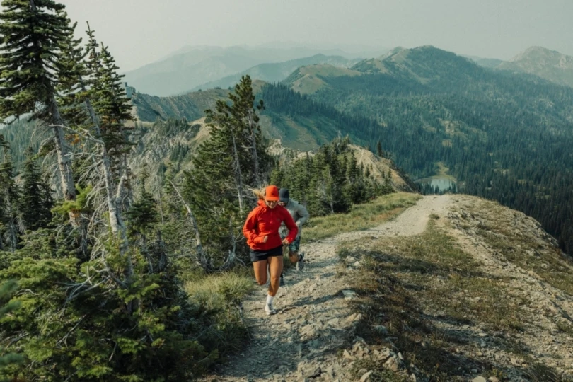 two people on mountain running up trail