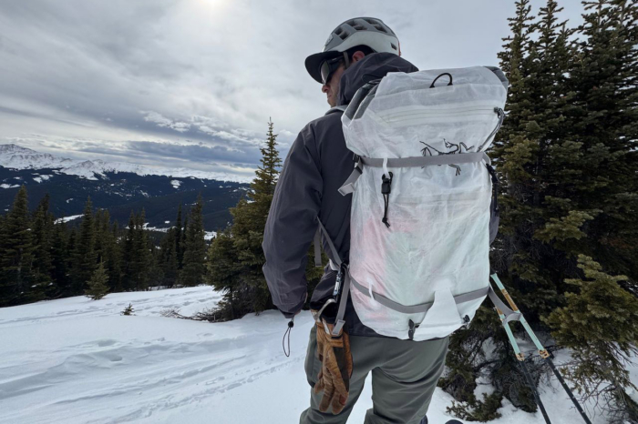 The Alpha SL backpack worn while standing on a snowy slope overlooking the mountains