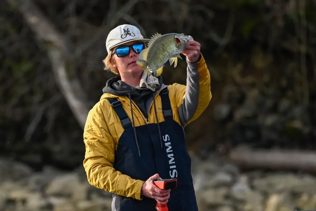 Dylan Nutt holding a smallmouth bass while fishing the Bassmaster Classic