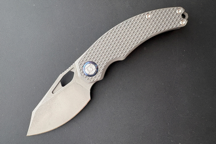 Kunwu Compadre opened, showing the stonewashed blade and textured handle against a dark background