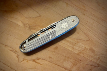 Victorinox Synergy X Alox multitool closed on a wooden table
