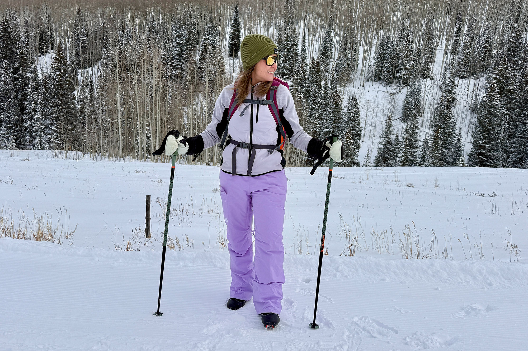 A skier stands on a snowy trail wearing The North Face Freedom Insulated Bibs during a winter outing