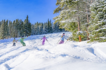 skiers ride down a mountain