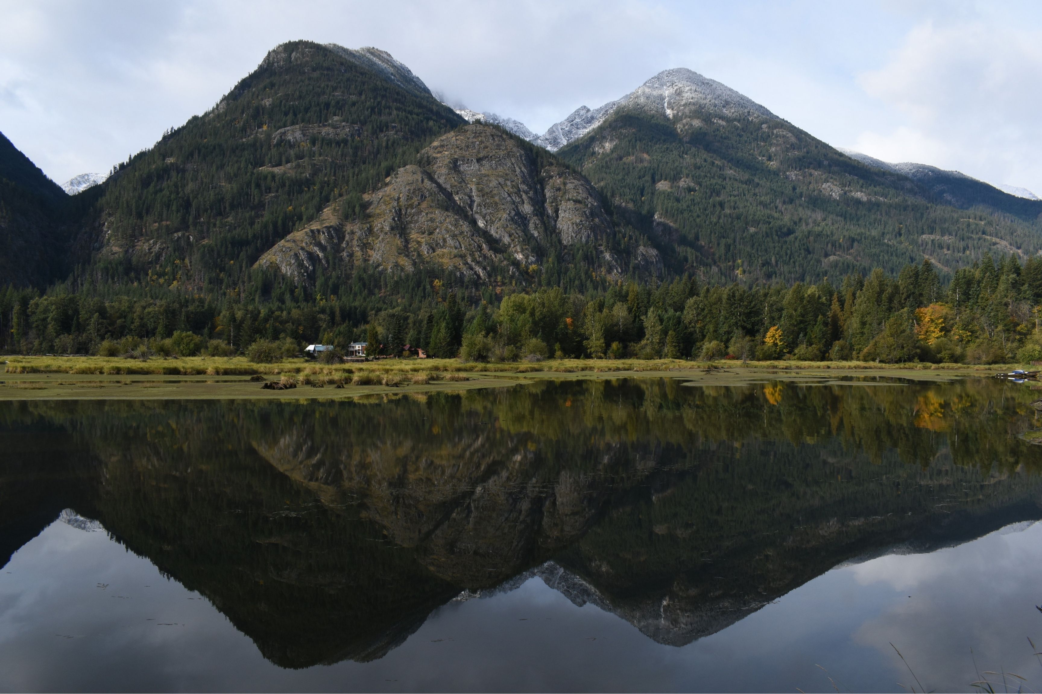 lake with mountains overlooking it and reflected in water