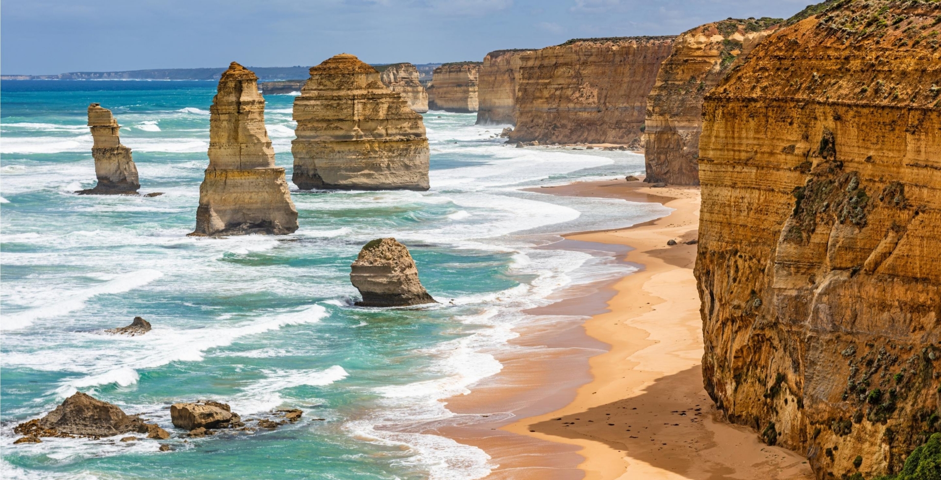 blue beach with rocky stone cliffs and pillars in the sea