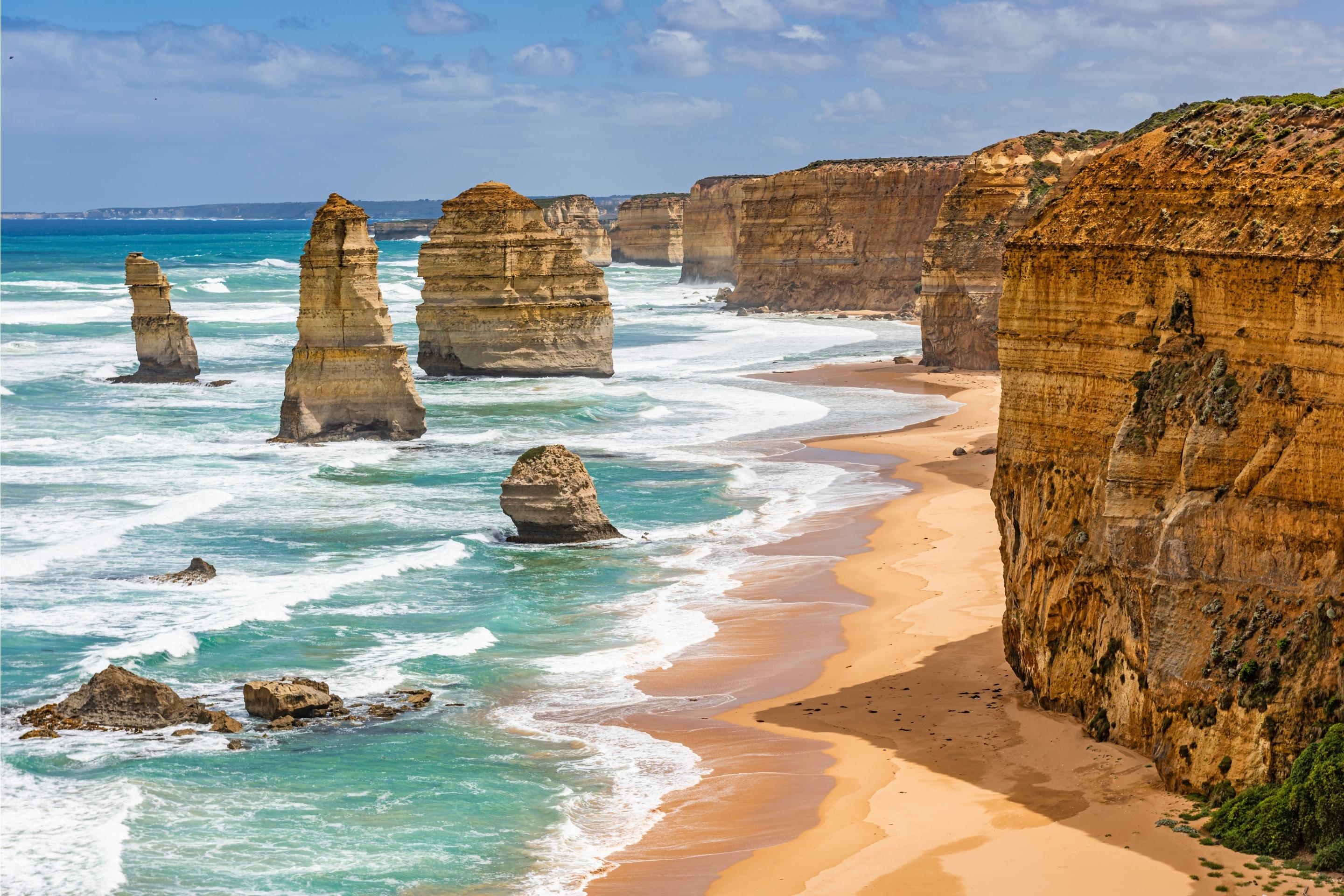 blue beach with rocky stone cliffs and pillars in the sea
