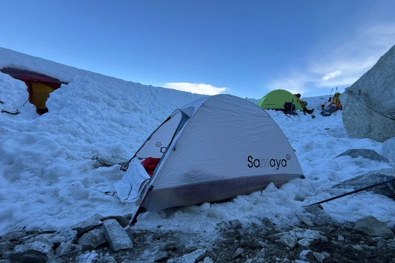 Lightweight Samaya tent pitched on rocky alpine ground near jagged peaks and a lake