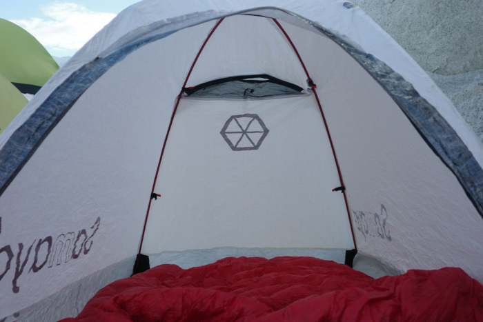 Inside view of the tent with a sleeping bag laid out and poles forming the structure