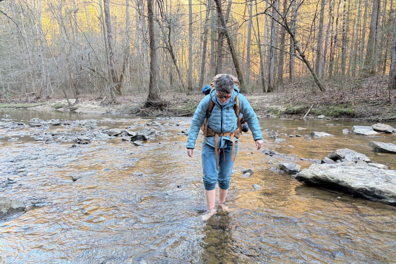 person wades across stream