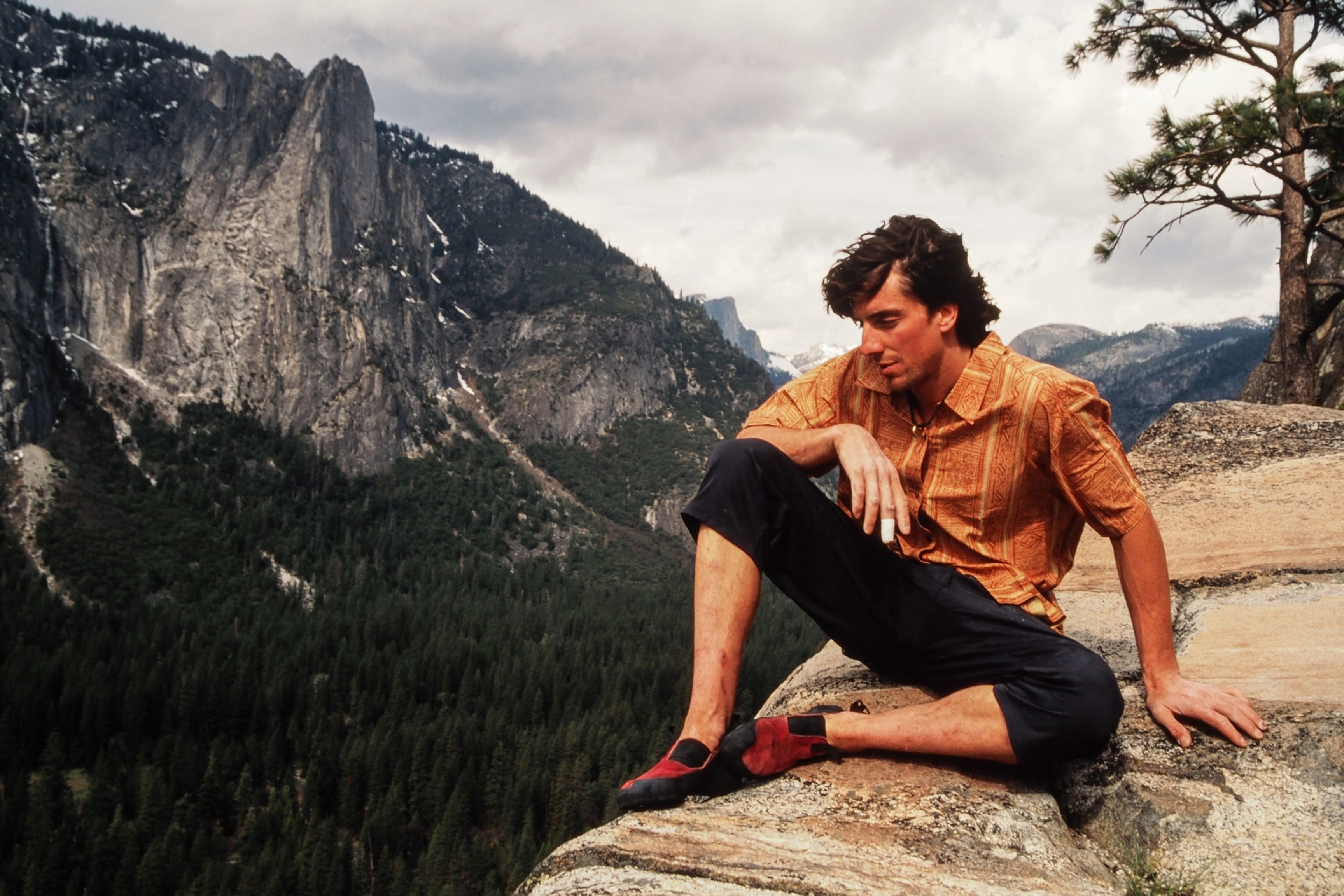 man sits on rock in yosemite