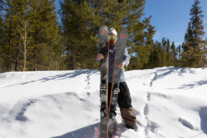Skier holding Blizzard Canvas 100 skis in deep snow