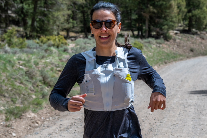 A woman wearing the Nathan AeroZip 1L run vest