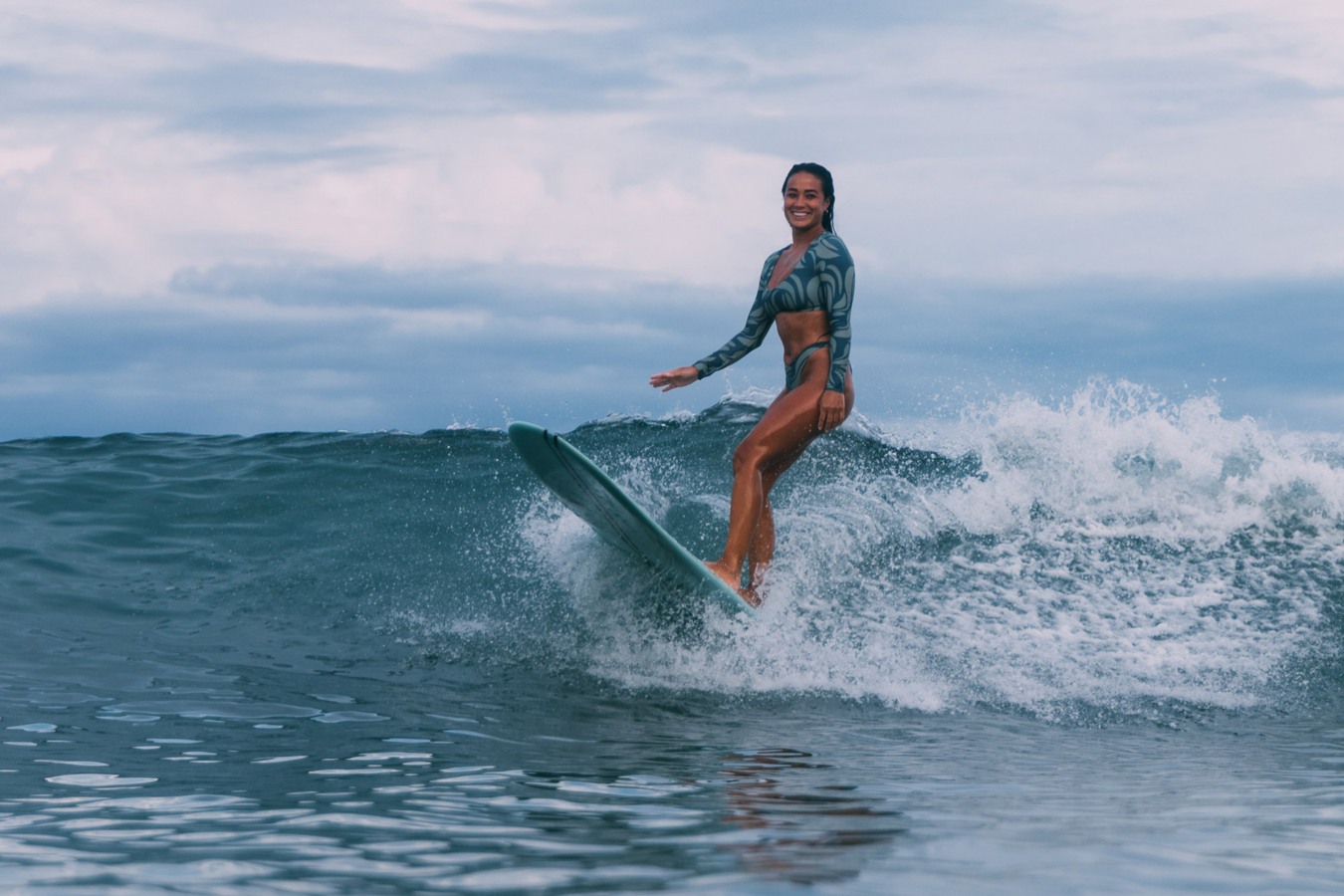 Woman surfing in Jolyn women's surf swimsuit