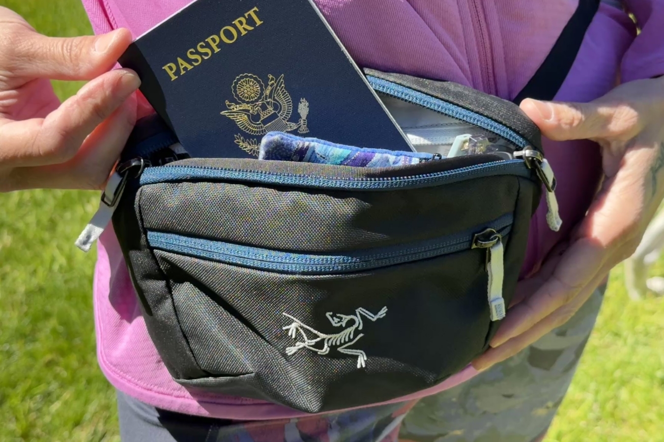 Passport and small pouch tucked inside a black Arc’teryx Mantis 1 Waist Pack worn at the waist