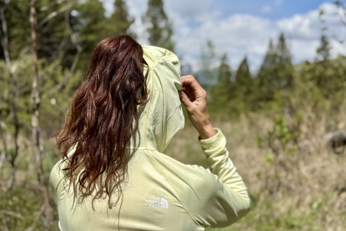 Woman wearing a sun shirt with a slit for a pony tail