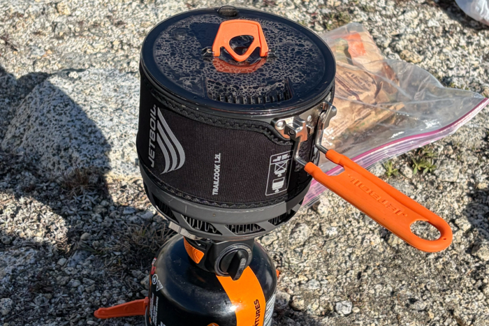 Closeup of a Jetboil TrailCook pot and burner with orange handles on a fuel canister