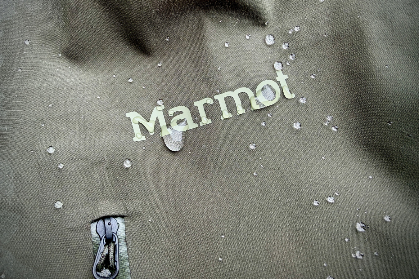 Water beading on the Marmot PreCip Evo Pro jacket fabric near the chest logo