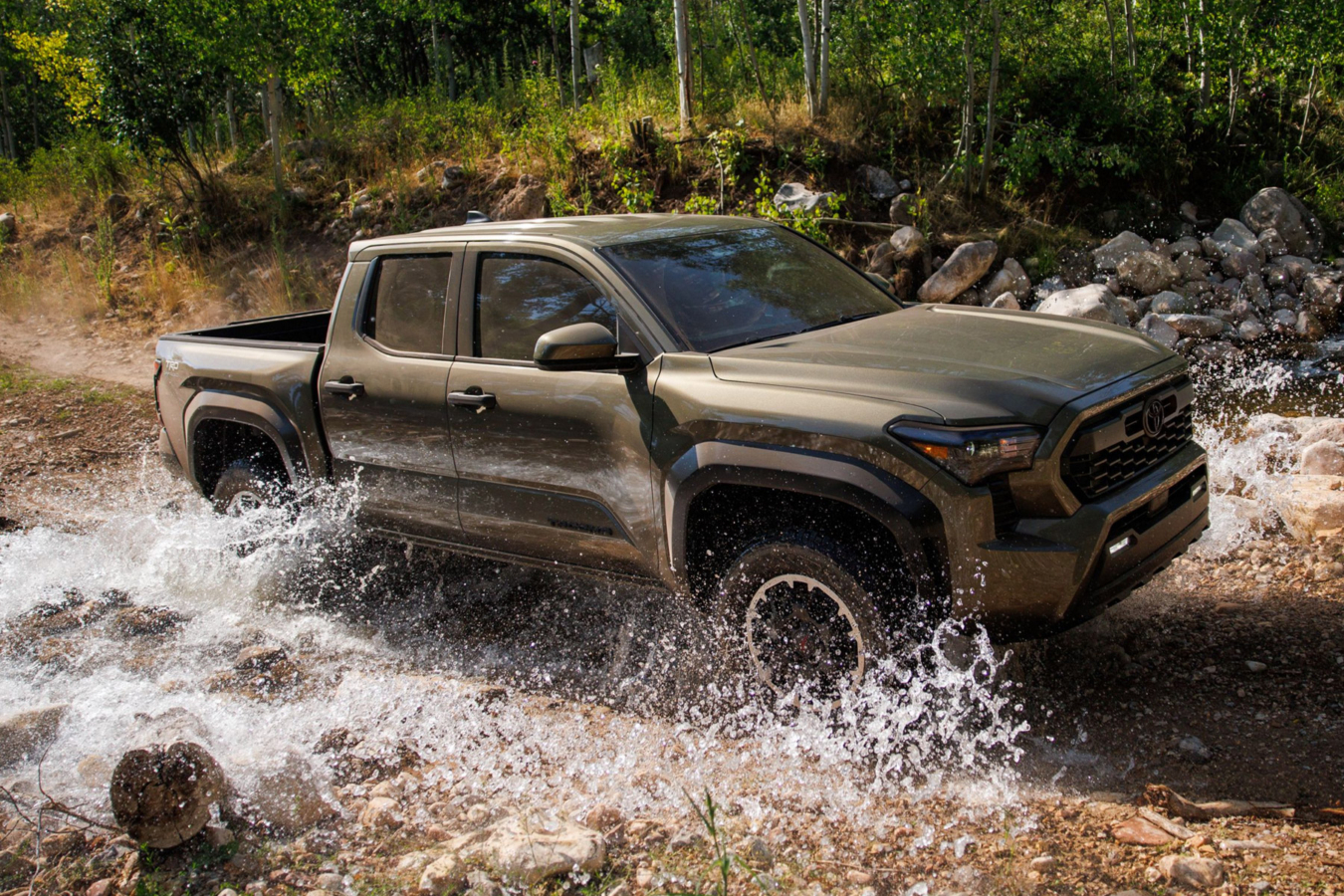 Toyota Tacoma TRD splashing through a rocky water crossing