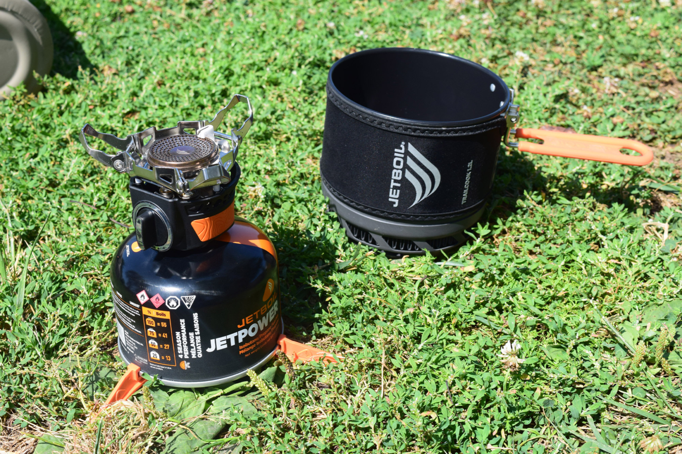 Jetboil burner and TrailCook pot set up separately in the grass
