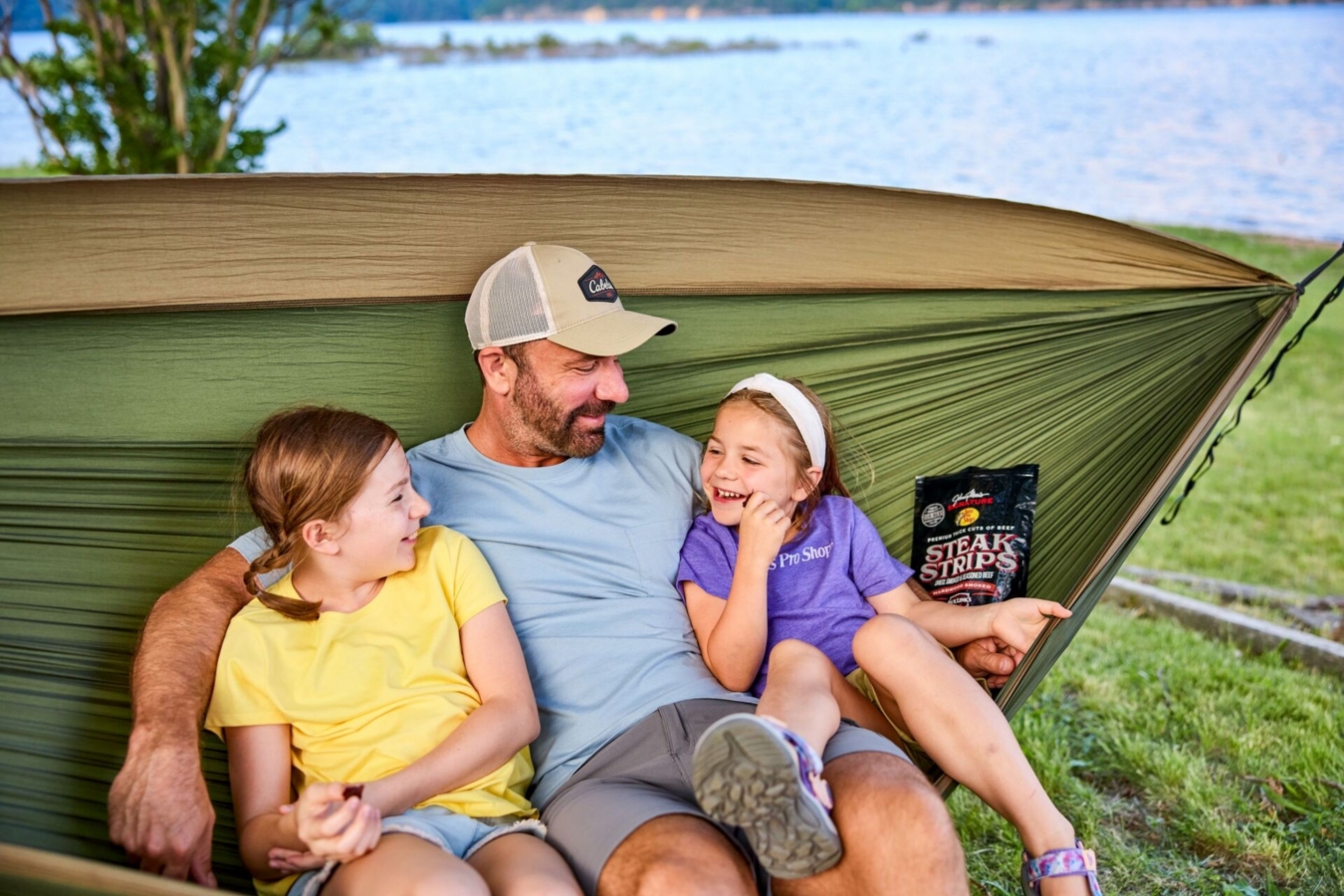 dad sits in hammock with two daughters
