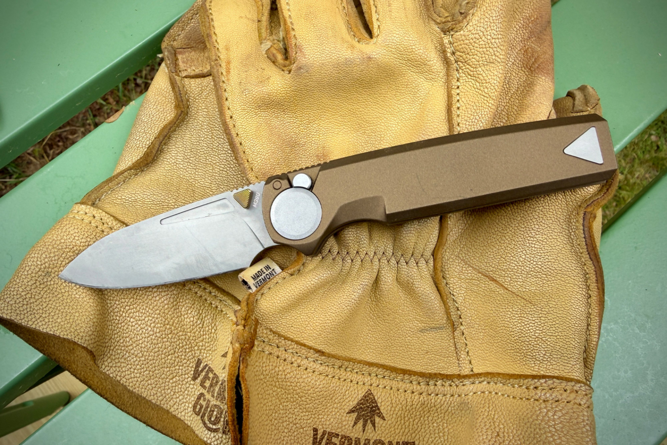 RMX Thumbstud knife resting on a worn leather work glove.