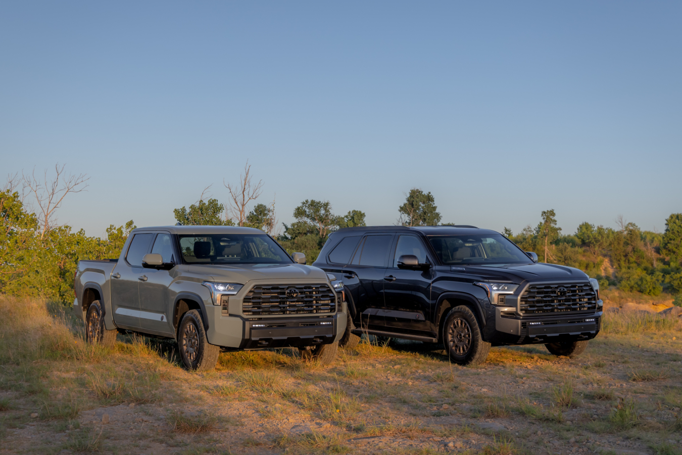 Gray 2027 Toyota Tundra and Sequoia are parked next to each other off-road, front 3/4 view