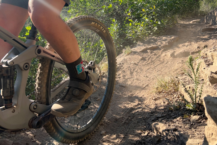 Crankbrothers mountain bike shoe on a flat pedal climbing a rocky trail