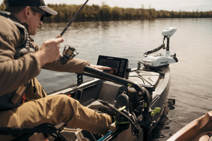 A kayak angler using a fish finder on the water.