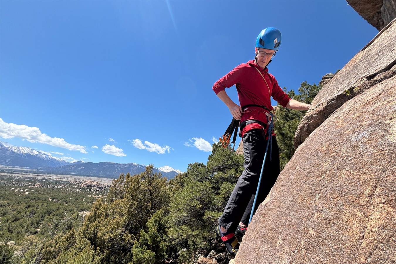 Climber wearing a Petzl Adjama harness on a sunny rock route