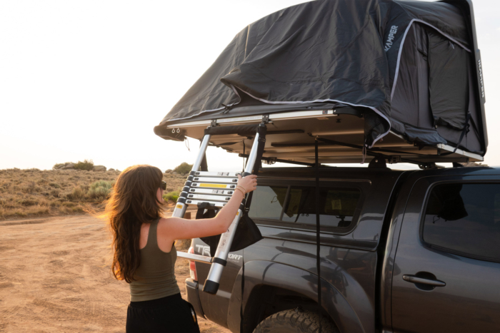 Woman positioning the ladder on an open iKamper rooftop tent