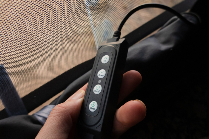 Hand holding the control panel inside the iKamper rooftop camper