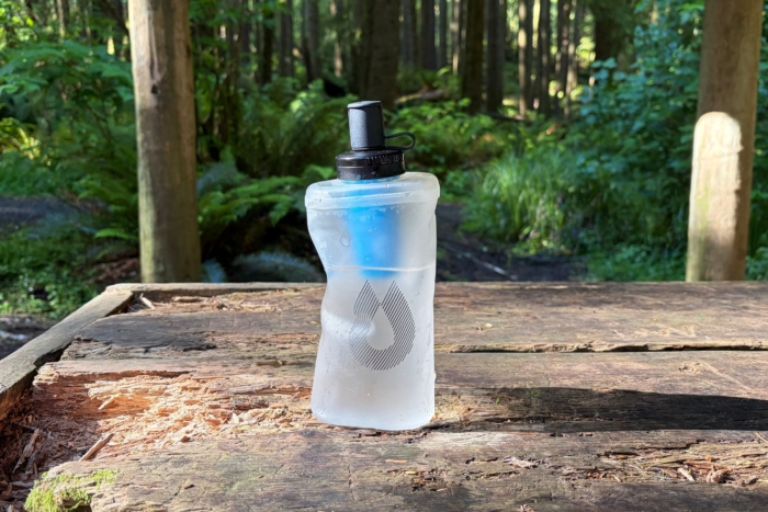 soft flask water bottle filled with water on top of picnic table