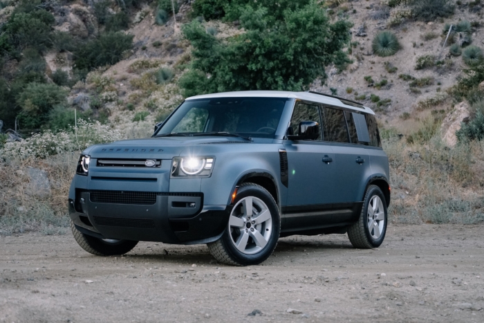 A matte blue 2026 Land Rover Defender 110 is parked on dirt