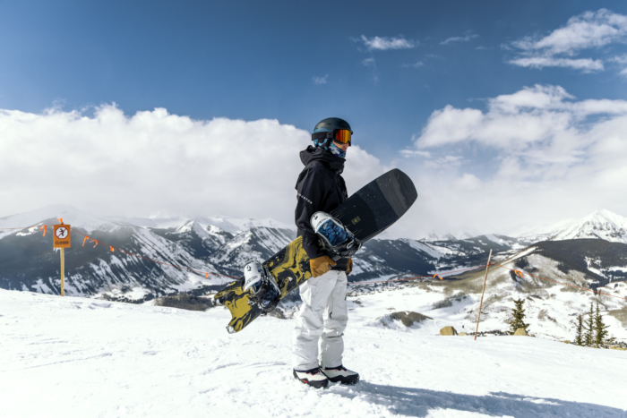 snowboarder standing holding snowboard