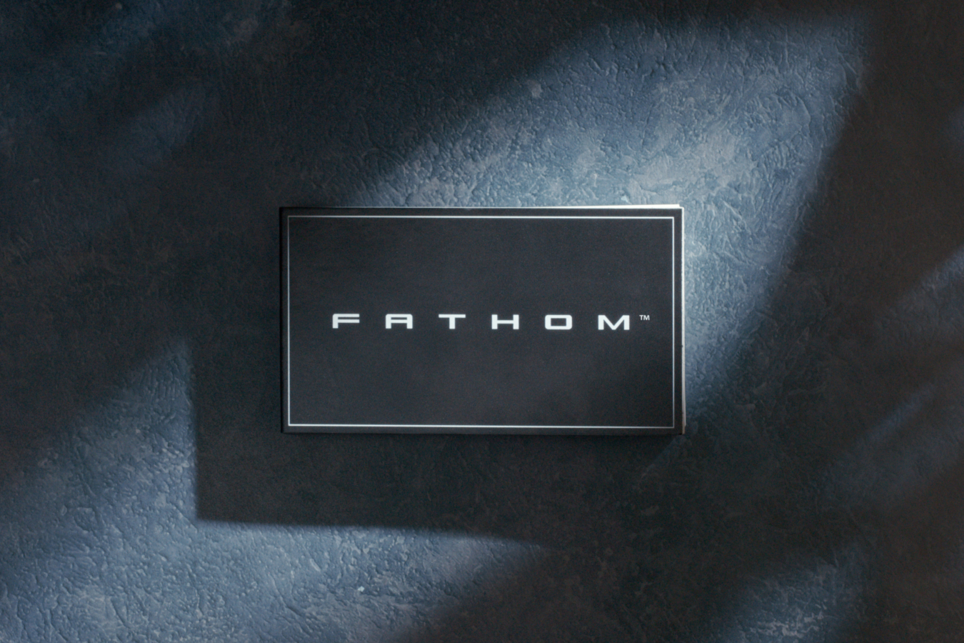 A flipbook with the word Fathom on it in white block letters