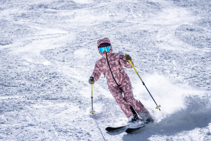skier taking downhill carve throwing up snow