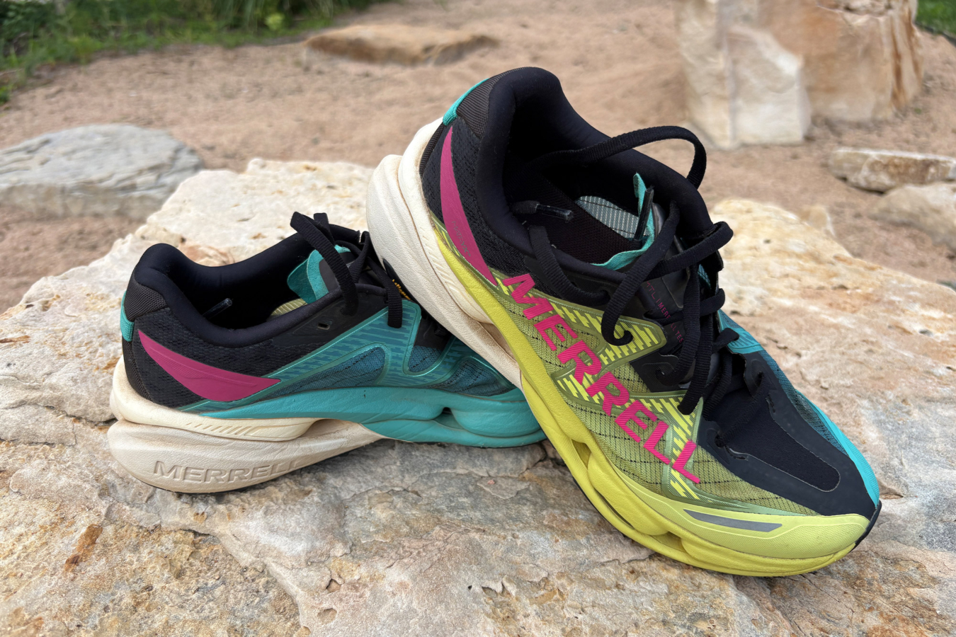 Colorful Merrell MTL SpeedArc Peak shoes stacked on a rock