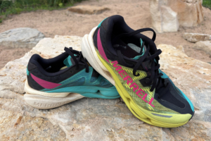 Colorful Merrell MTL SpeedArc Peak shoes stacked on a rock