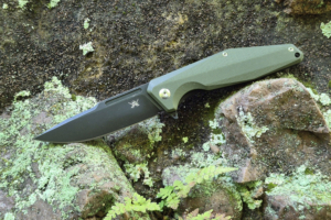 Skallywag Tactical Iron Jaw knife open on a moss-covered rock