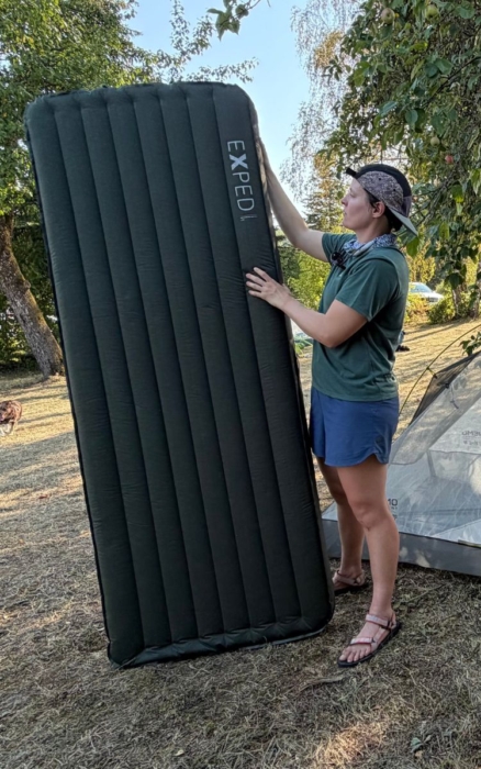 person stands next to sleeping pad