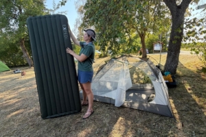 person stands next to sleeping pad