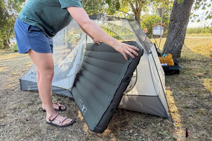 person goes to put pad in tent