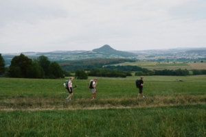 three hikers on trail with mountain background