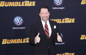 Voice actor Peter Cullen gives a double thumbs up on a step-and-repeat