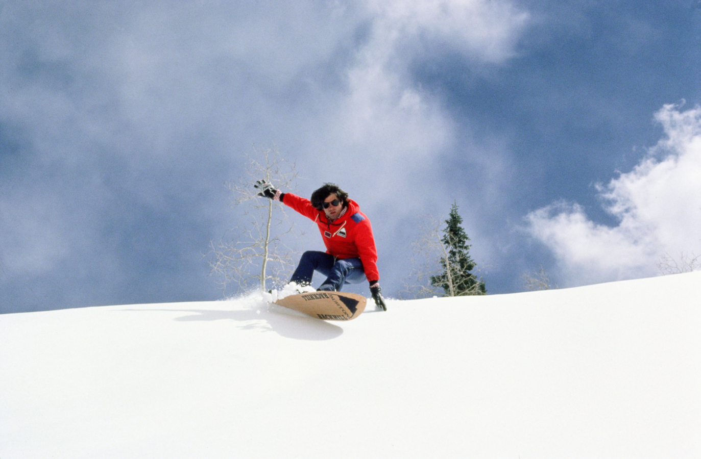 Historical image of Jake Burton snowboarding in powder in the 1980s