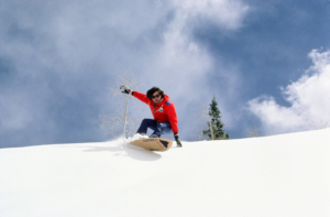 Historical image of Jake Burton snowboarding in powder in the 1980s